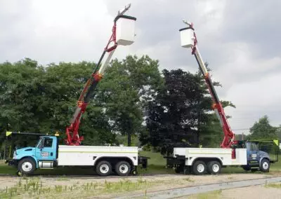 two high reach trucks near trees