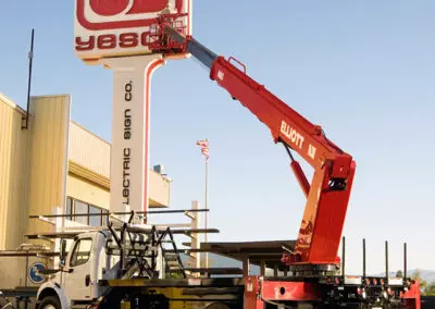 worker installing sign with red m 85 truck